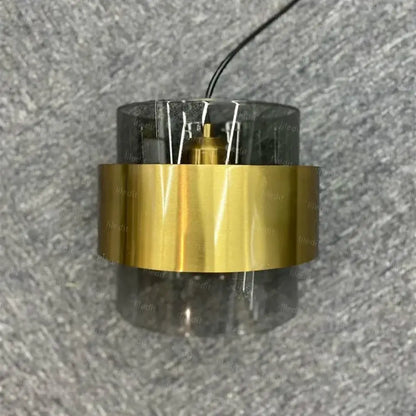Modern brass and smoked glass pendant light with gold wrought iron cylindrical lamp and visible internal wiring for dining room decorbites gold wrought
