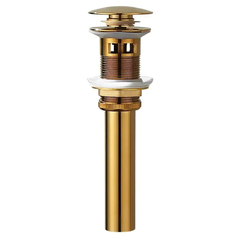 Modern brass and white ceramic basin waste drain with gold-toned metal cylindrical body and fluted top cap for bathroom sink