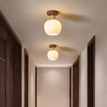 A warm amber glass ceiling light with wooden mount and copper socket for modern brass and wood led ceiling decorbites light