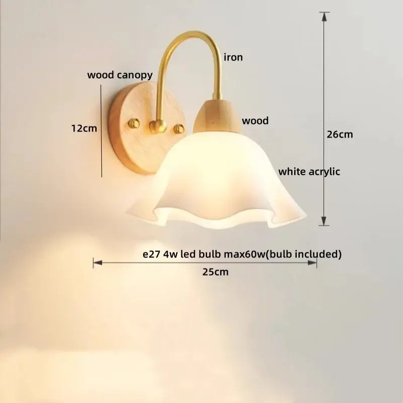 A modern brass and wood tulip led wall lamp with warm brass arm and ruffled white acrylic shade for living room decor