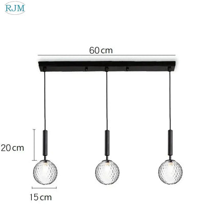Black metal pendant light with three textured decorbites glass ball led globes suspended by black cords for dining room decor