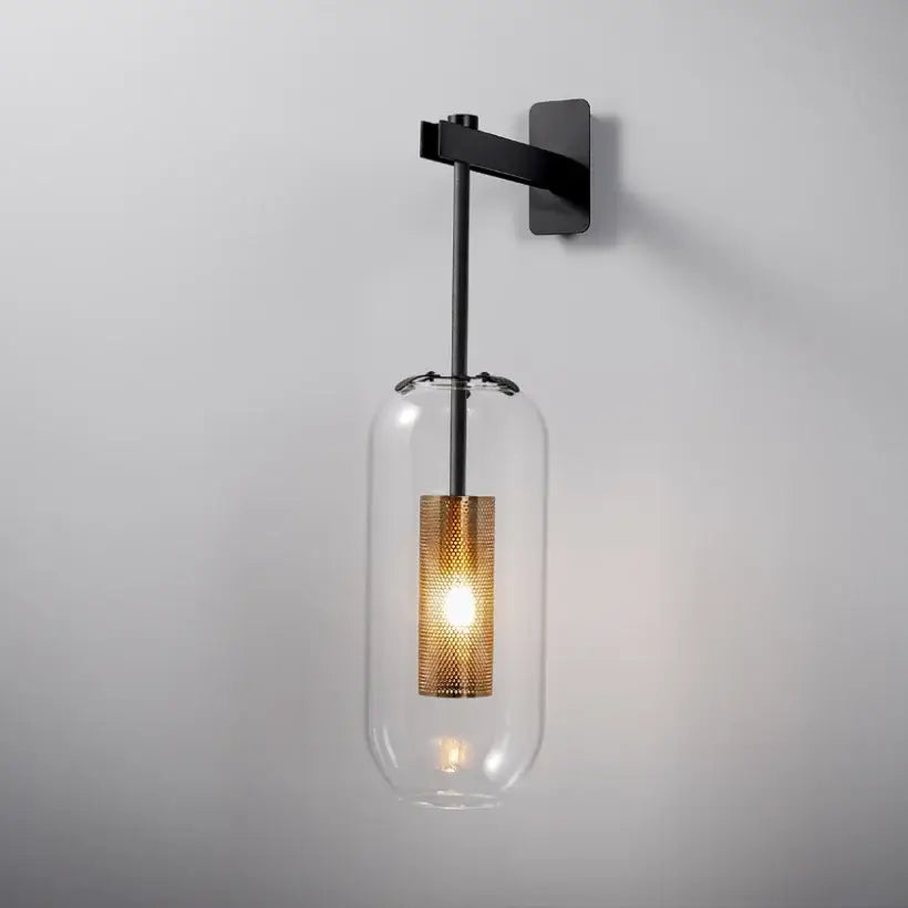Modern brass and black wall sconce lights with clear glass housing and illuminated gold mesh shade for bedroom use