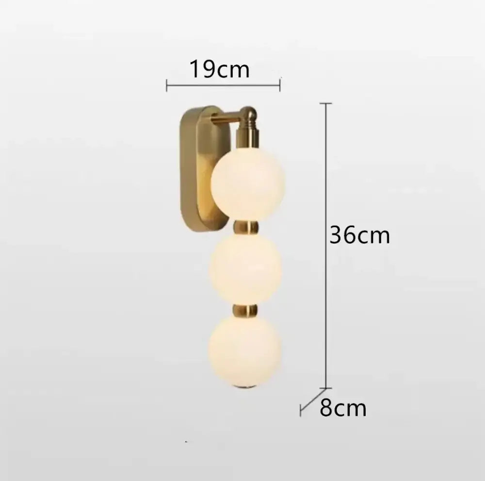 Modern brass circle ring led pendant light featuring a brass-finished wall sconce with three frosted glass spheres