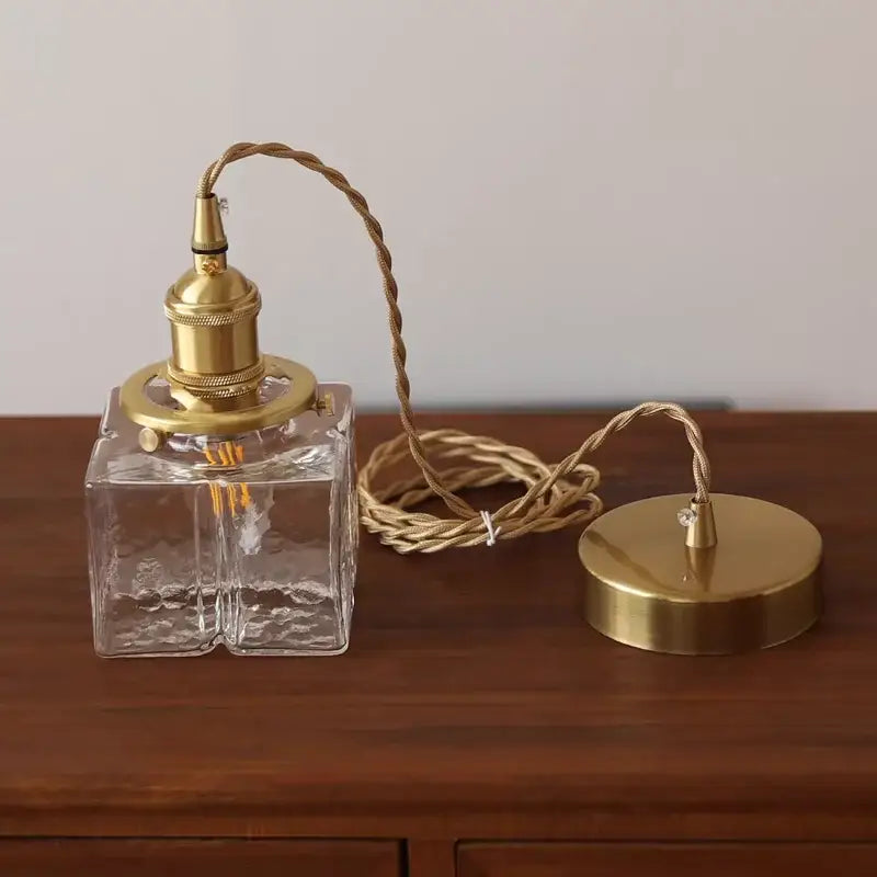 Modern brass clear glass LED pendant light featuring a textured glass square lamp with a brass-finished base ideal for dining room decorbites clear glass