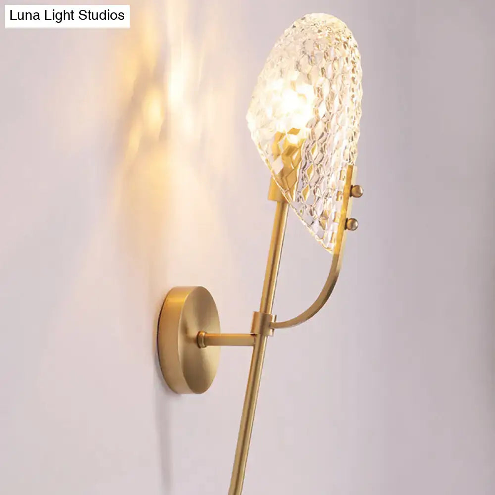 A gold-toned modern brass crystal beveled light fixture hallway sconce with a textured faceted crystal shade