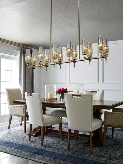 Modern brass crystal bronze pendant lamp with clear glass shades and warm glowing bulbs for dining room decorbites