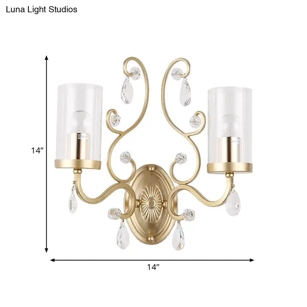 Modern brass crystal wall mounted light with gold-toned curved arms and glass shades featuring crystal teardrop accents