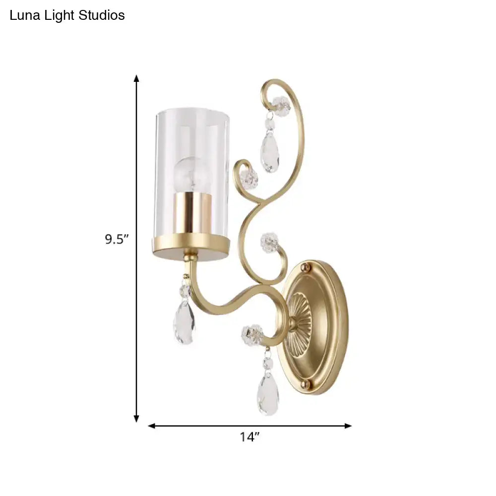 Modern brass wall mounted light with gold-toned finish clear crystal teardrop accents and cylindrical glass shade