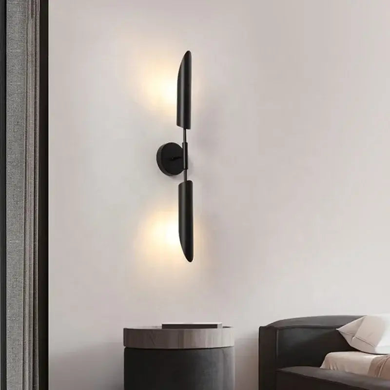 Modern brass cylindrical wall light with black minimalist matte finish and elongated vertical arms for living room decorbites golden luxury wall