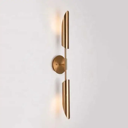 Modern brass cylindrical wall light with sleek elongated leaf-shaped shades on a minimalist base for golden luxury wall decorbites