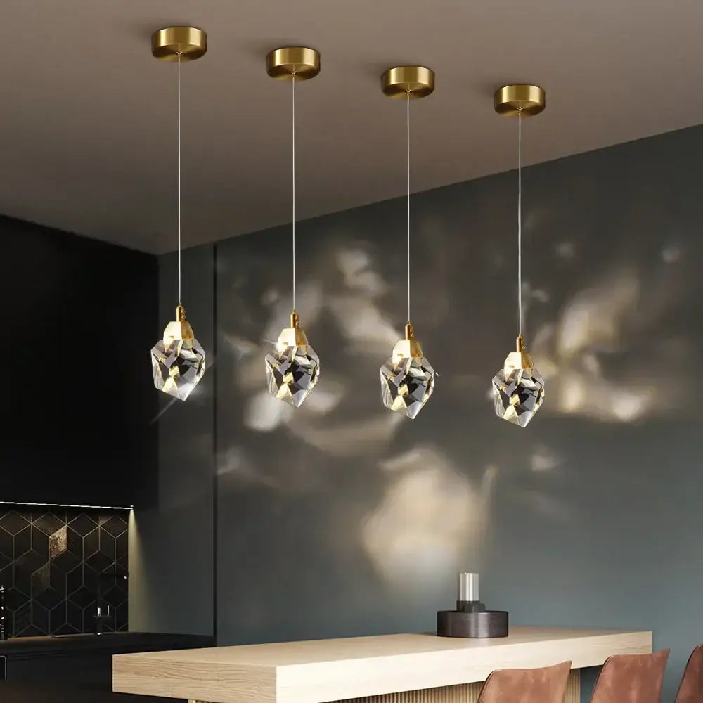 Four elegant decorbites crystal led pendant lights with gold-finished fixtures and faceted glass globes for living room