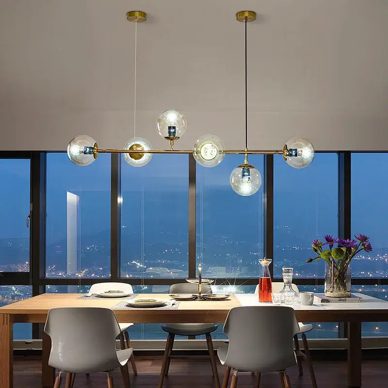 Modern brass five globe glass pendant lights featuring clear glass pendant globes for dining room use