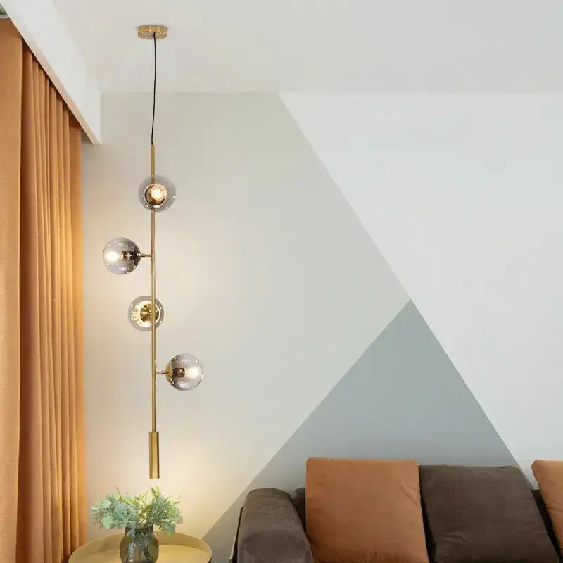 Modern brass five globe glass pendant lights with frosted globe shades for dining room featuring vertical suspension