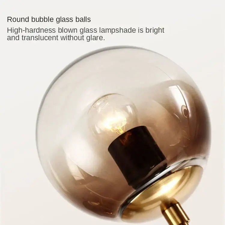 Modern brass five globe glass pendant lights featuring a round translucent amber glass pendant light with brass base