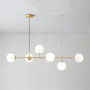 Modern brass pendant light with five frosted golden glass ball shades for dining room illumination