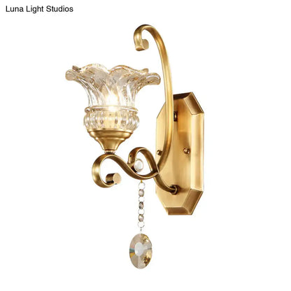 Modern brass flower sconce wall lamp with gold-toned curved arm and clear fluted glass light fixture for bedroom