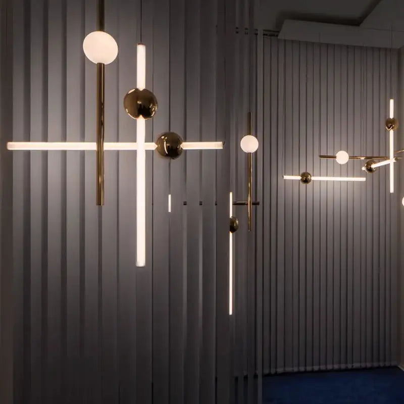 Modern brass pendant lights with gold-finished metal arms and spherical glass pendant shades for dining room use