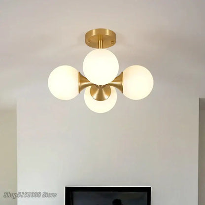 Modern brass decorbites glass ball led ceiling lights with gold-toned fixture and four frosted glass globe shades for living room