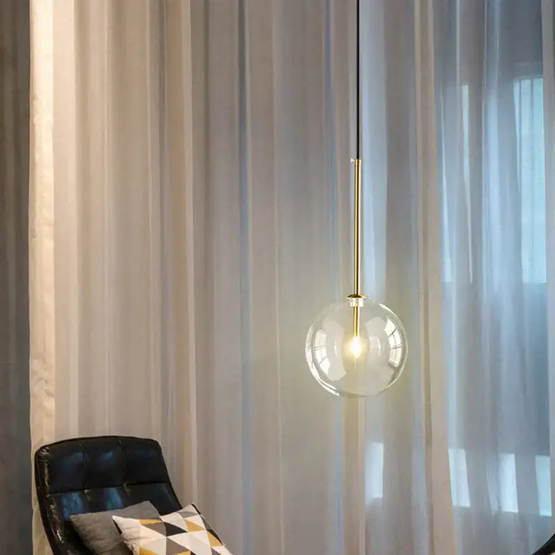 Modern brass glass ball led pendant lamp featuring a clear glass globe and brass rod for living room decorbites lighting
