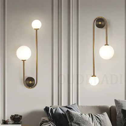 Modern brass glass ball led wall light featuring gold-toned metal arms and frosted glass globe shades for bedroom decorbites wall light