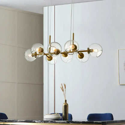 Modern brass glass ball pendant light featuring gold-toned metal and clear glass globe shades for kitchen decorbites decor