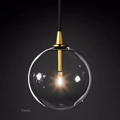 Modern brass glass ball pendant light with clear glass globe, brass fixture, and black cord for kitchen decorbites pendant light