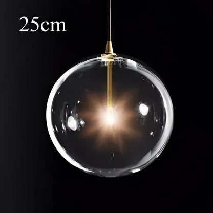 Modern brass glass ball pendant light with gold-toned metal fixture and illuminated decorbites glass ball pendant inside