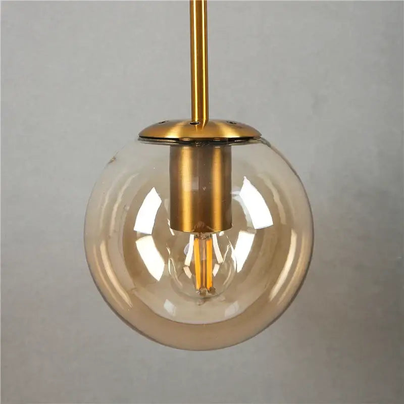 Modern brass glass ball wall lamp with clear glass globe gold-toned metal and exposed filament bulb decorbites glass ball lighting