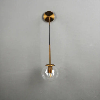 Modern brass glass ball wall lamp with clear amber globe and brass-finished slender stem for bedroom decorbites wall lamp