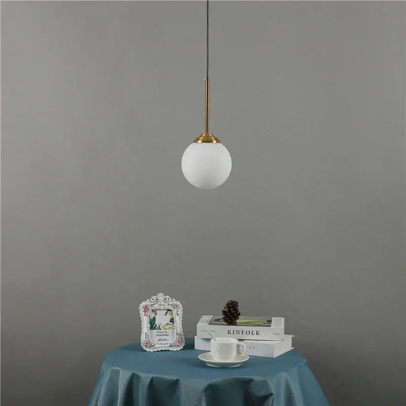 Minimalist modern brass glass ball wall lamps featuring a frosted white glass globe and slender brass stem for bedroom decorbites glass ball pendant light