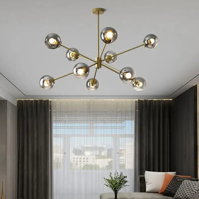 Modern brass glass chandelier with clear glass shades featuring spherical globes for elegant living spaces and dining rooms