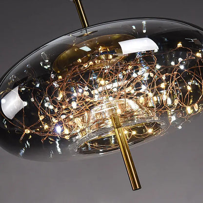 Modern brass glass cord pendant light with a sleek dark glass dome and copper wire warm led string lights in iron finish
