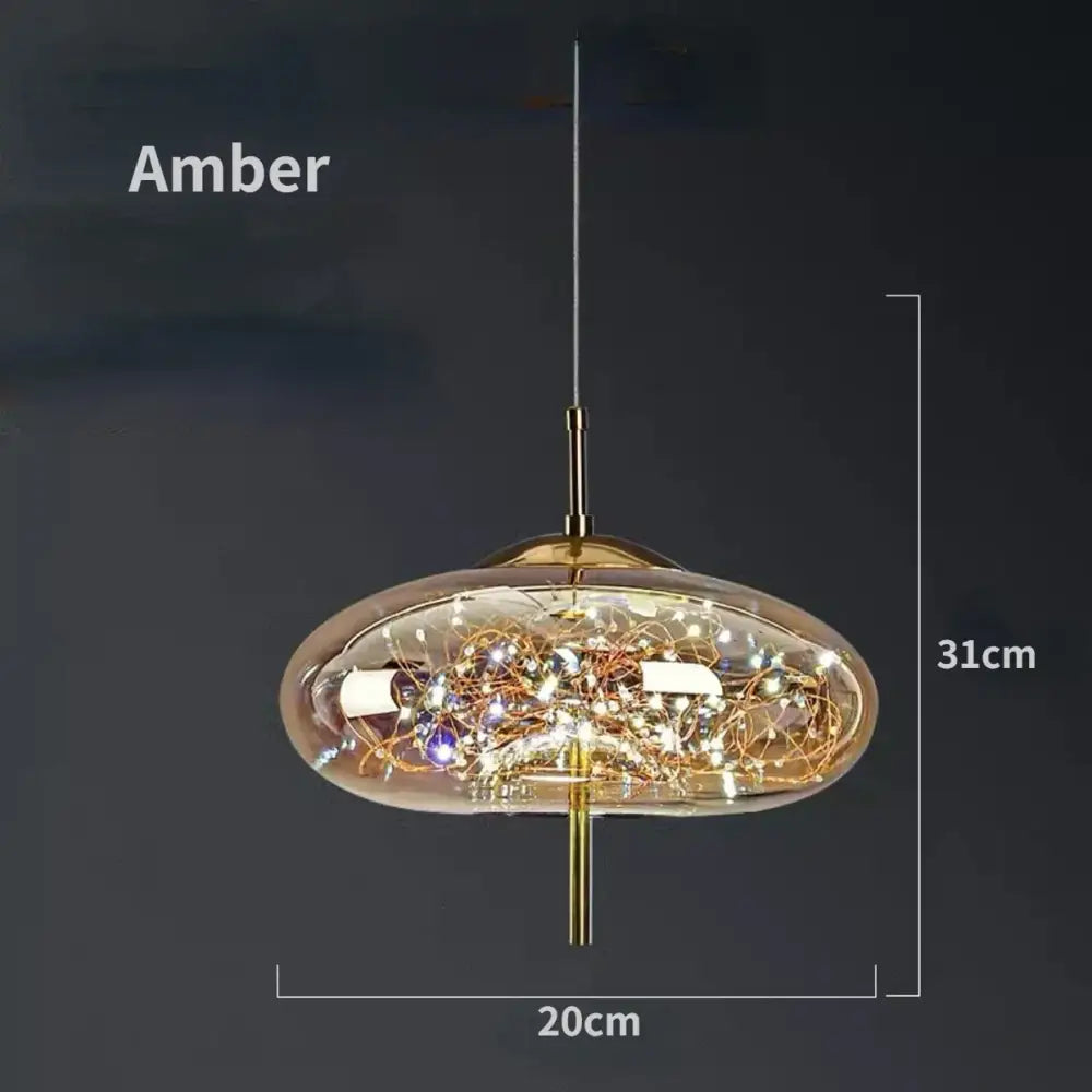 Modern brass glass pendant light featuring an amber-colored glass pendant with a golden metal frame and intricate wirework design