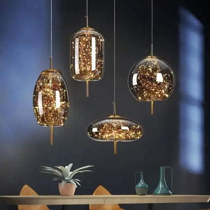 Four modern brass glass pendant lights with golden accents and warm glowing string lights for bedroom chandelier use
