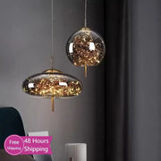 Two modern glass pendant lights with brass fixtures and golden filament strings for bedroom LED chandelier use