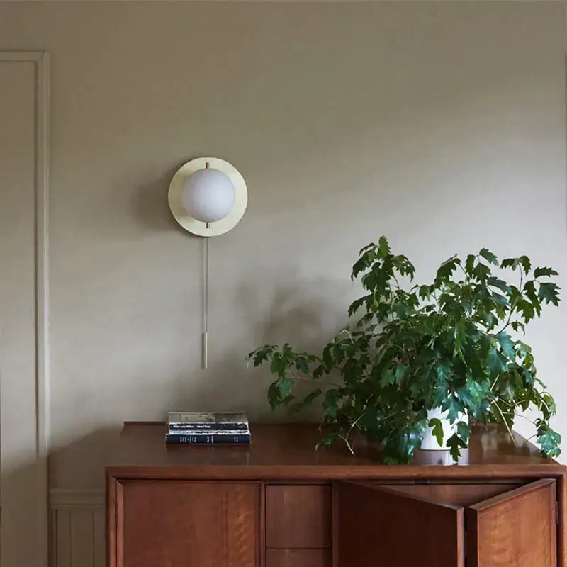 Modern brass glass round wall lamp with frosted glass globe and circular brass base for bedroom wall lighting