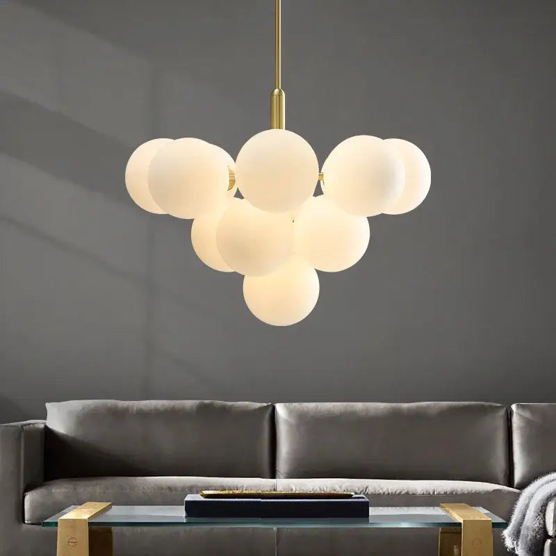 Modern brass globe pendant lamp with frosted glass spheres and brass accents for dining room lighting