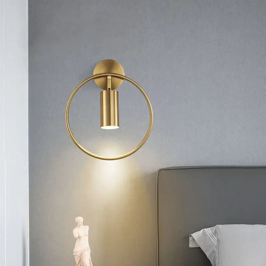 Modern brass gold adjustable led wall sconce with a gold-toned circular base and cylindrical light for corridor use