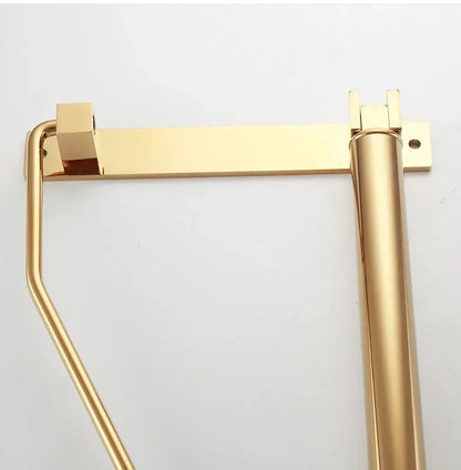 Modern brass gold wall clothing rack featuring a gold-colored metal toilet paper holder with sturdy mounting brackets decorbites brass gold