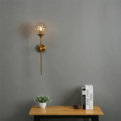 Gold-toned modern brass golden glass ball wall lamp with clear glass globe and exposed filament bulb for bedroom sconce decorbites golden glass