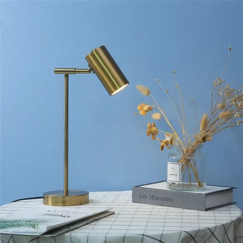 Brass-finished adjustable table lamp with cylindrical head and slender stem ideal for study and reading decorbites golden table lamp