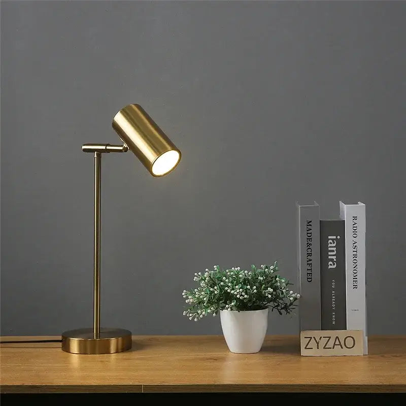 Brass-finished adjustable table lamp with cylindrical head and slender stem for modern golden table lamp decorbites