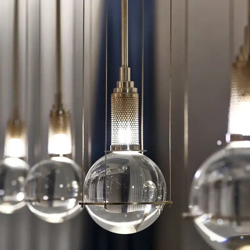 Modern brass honeycomb crystal ball led pendant light with clear glass globe and metal fixture for dining room decorbites