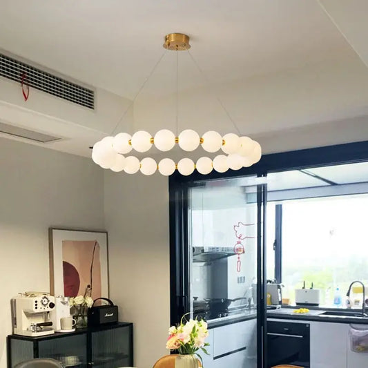A modern brass led pendant light with frosted glass spheres and gold-toned rods for living room decorbites brass led