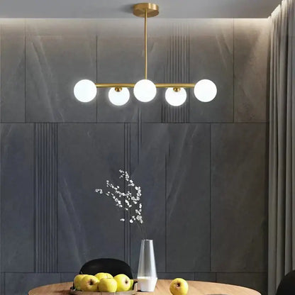 Modern brass led pendant lights featuring five frosted glass globe lights for elegant dining room decorbites brass led chandelier