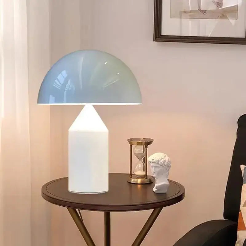 A modern brass mushroom metal led table lamp with a translucent light blue dome and white cylindrical base for decorbites atollo metal led