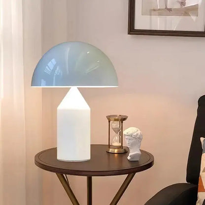 A modern brass mushroom metal led table lamp with a translucent light blue dome and white cylindrical base for decorbites atollo metal led