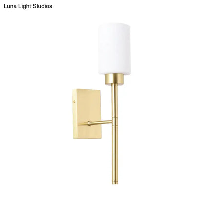 Modern brass wall light with gold finish and opal glass tube cylindrical shade for bedroom sconce lighting