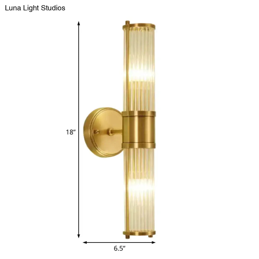 Modern brass ridged crystal wall light with gold-toned fixture and ribbed glass tubes providing warm diffused lighting