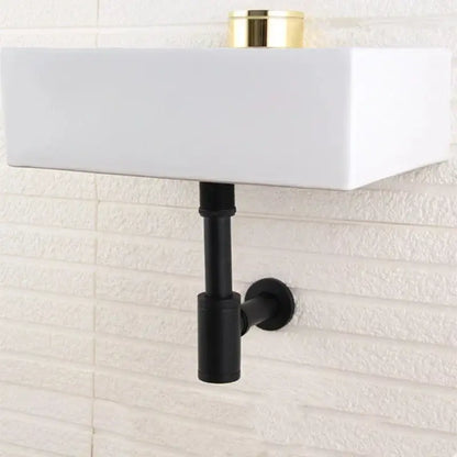 White rectangular wall-mounted sink with black matte pipe and modern brass round siphon p-trap set in gun grey